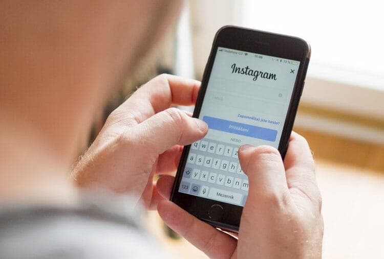 Man looking at Instagram log-in page on mobile phone 